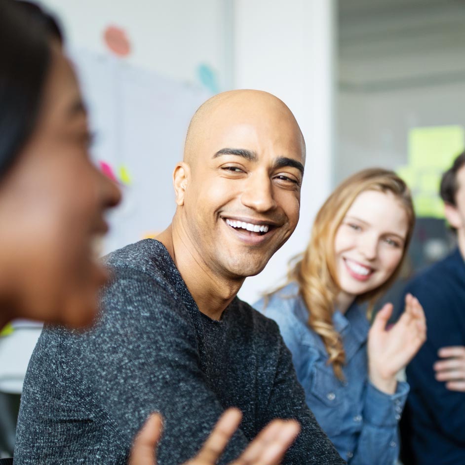 man smiling and laughing with others